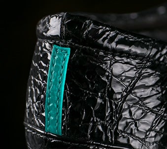 the heel of a pair of black patent tieks flats