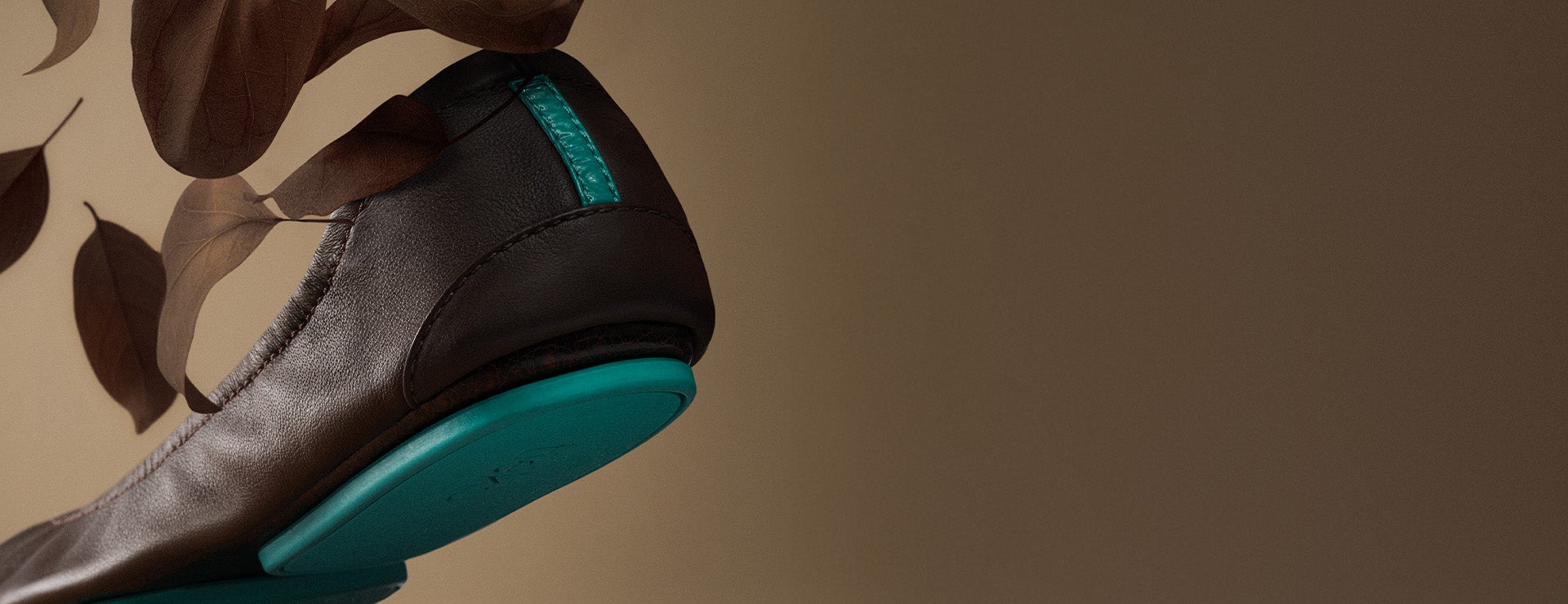 chocolate brown tieks ballet flats surrounded by falling leaves