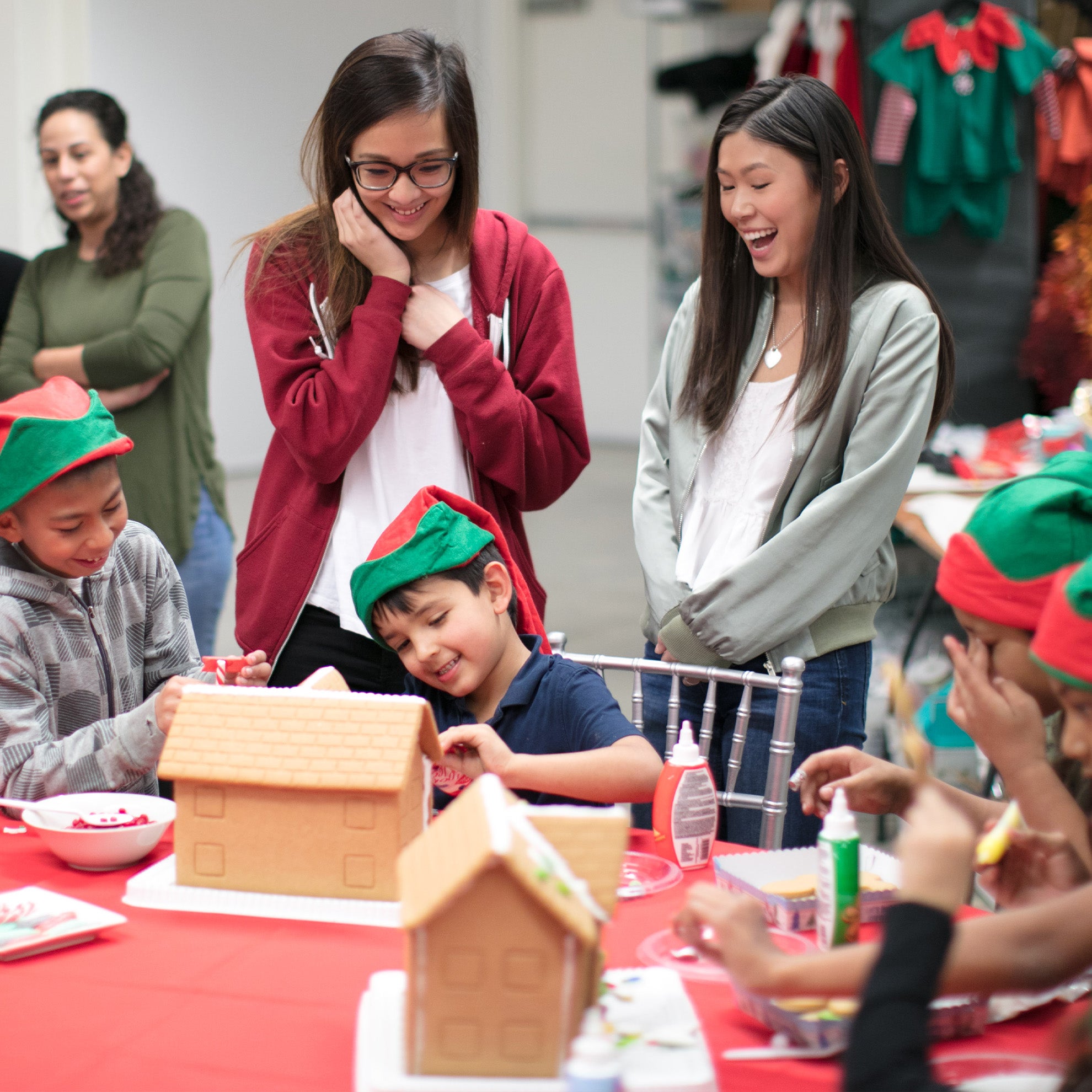 tieks employees and kids decorating gingerbread houses