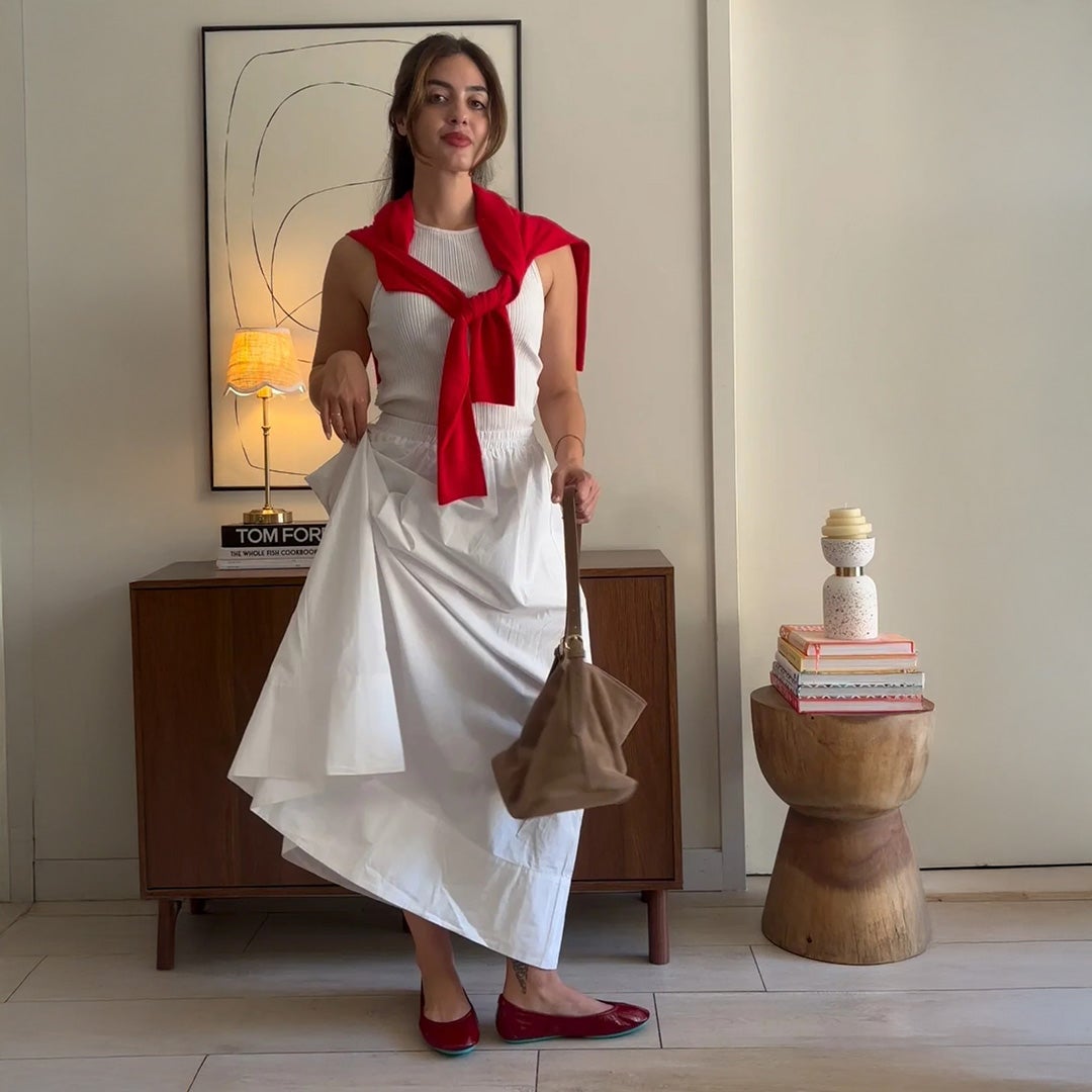 woman wearing ruby red tieks flats with a white maxi skirt