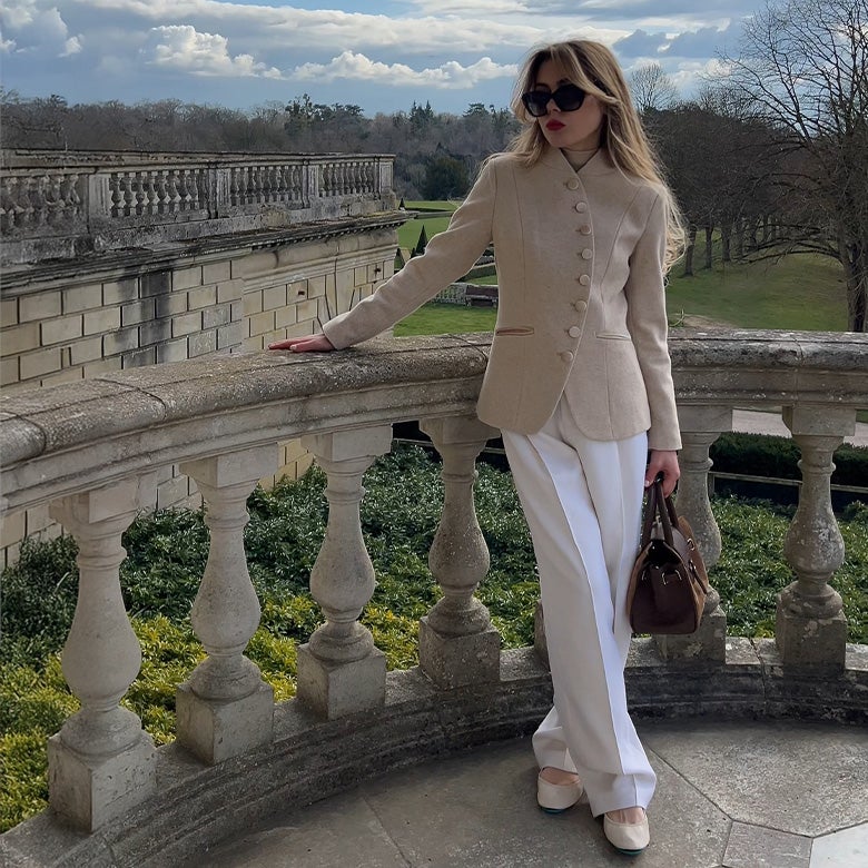 cream tieks ballet flats styled with white pants and a cream blazer
