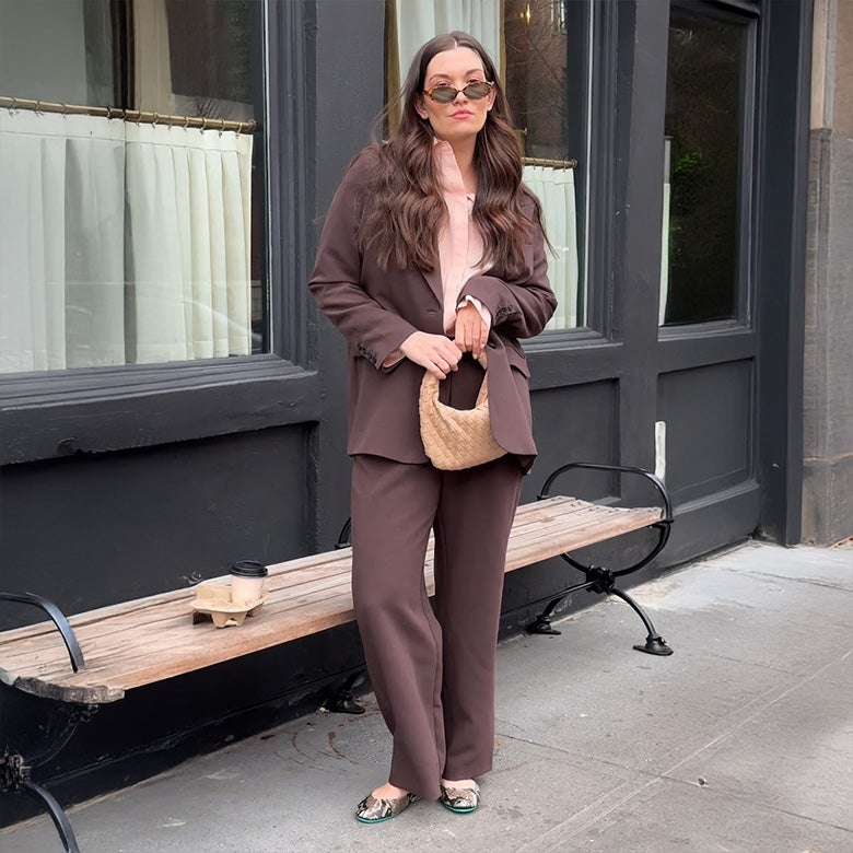 woman wearing copperhead snake print tieks flats with a brown suit set