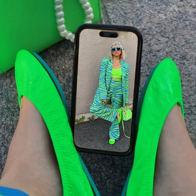 a phone screen displaying a woman wearing neon green tieks with a neon outfit