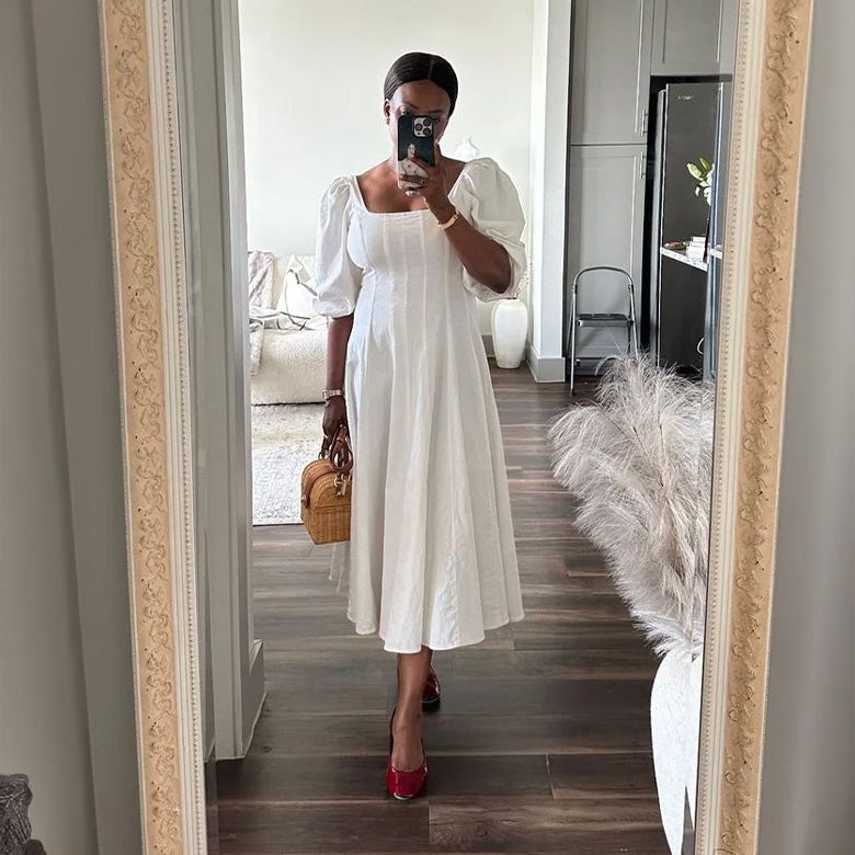 woman wearing ruby red patent tieks flats with a white dress