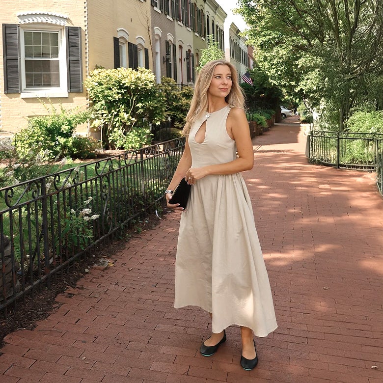woman wearing matte black tieks flats with a tan dress