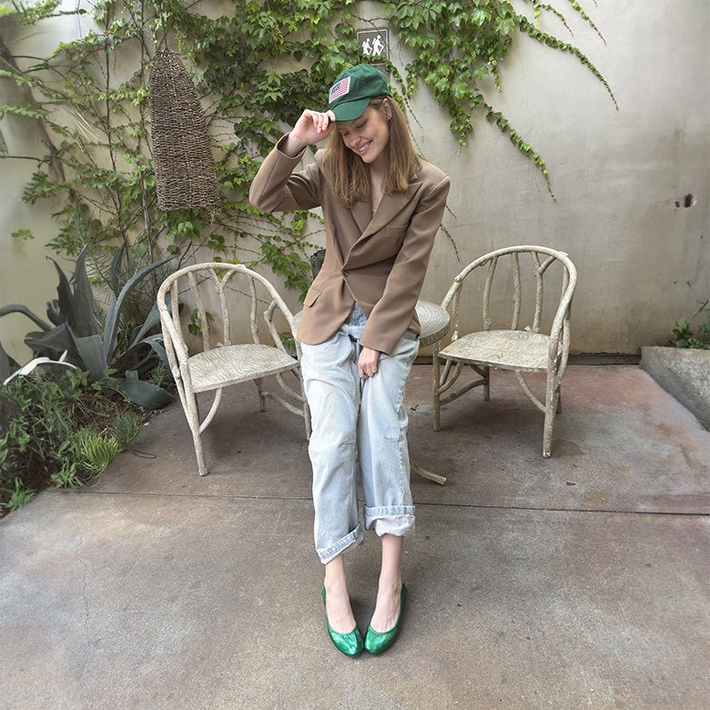 woman wearing emerald green patent leather flats with jeans and a blazer