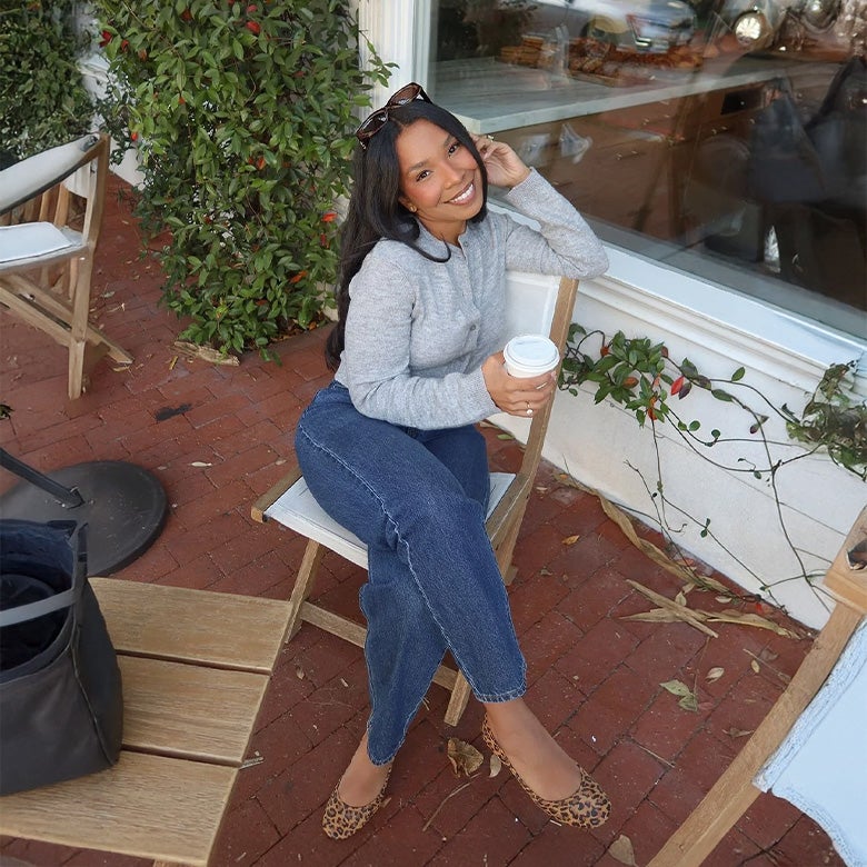 woman wearing leopard print tieks flats with jeans and a grey sweater
