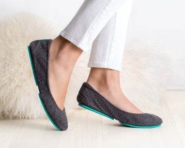 woman wearing white pants and greystone vegan flats 