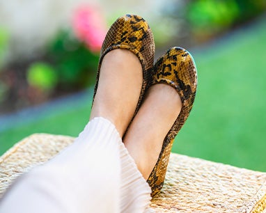 model wearing mocha snake print tieks flats with cream pants