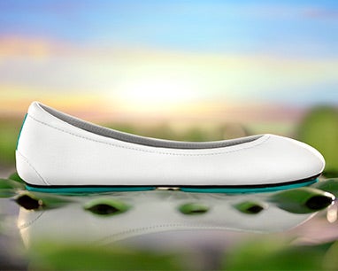white tieks flats in a lotus pond