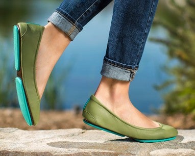 woman wearing blue jeans and olive tieks flats