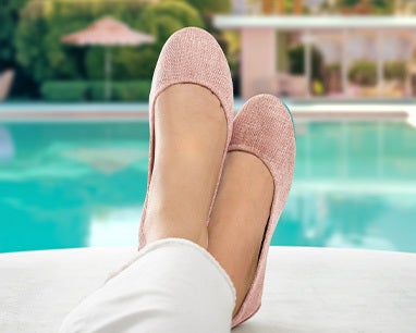 palm springs pink tieks flats on feet in front of a pool