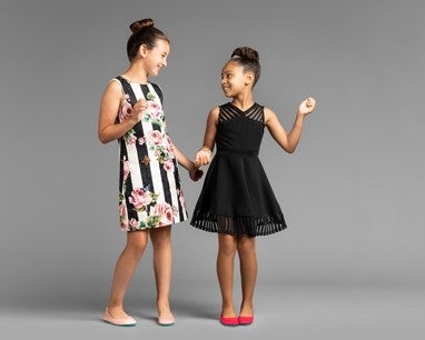 two girls in dresses, modeling cotton candy and razzleberry kids tieks flats