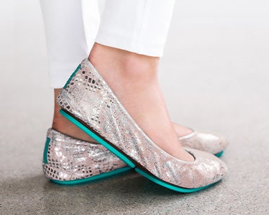 model wearing white pants and romantic blush tieks flats